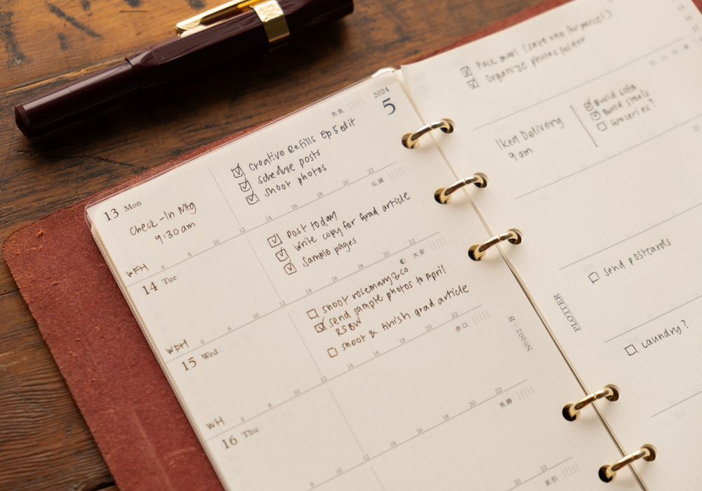 Close-up of weekly schedule notes inside a PLOTTER leather binder.