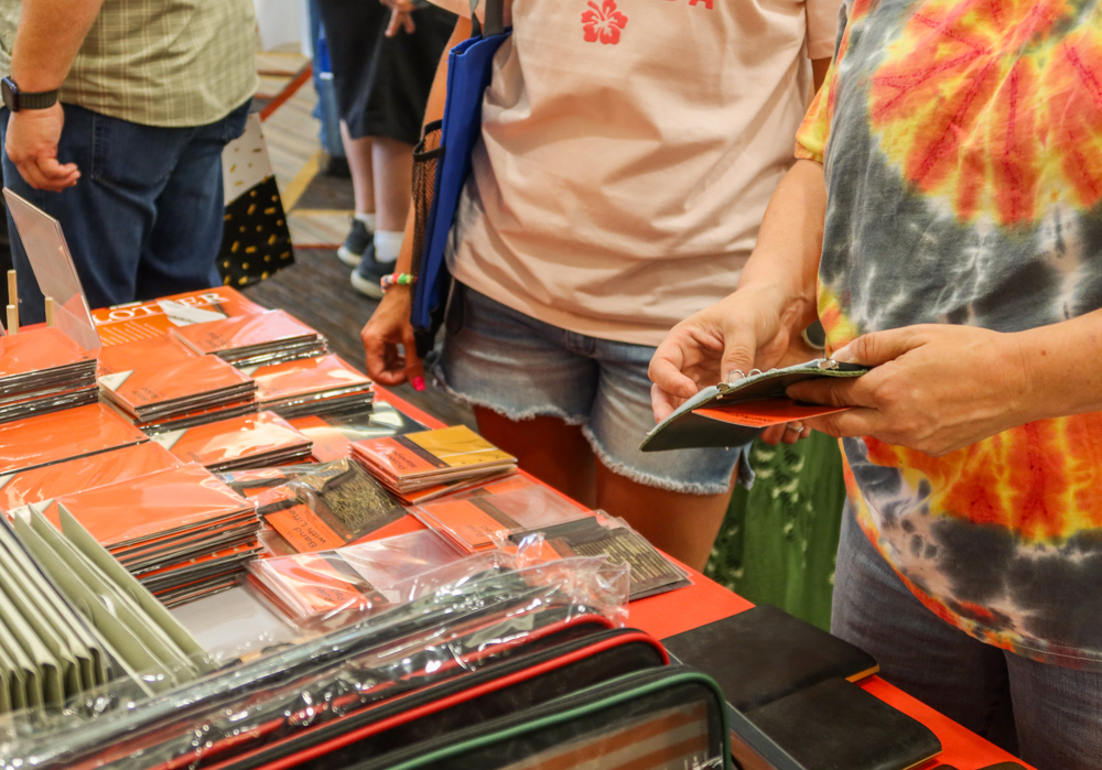 Customers picking up a PLOTTER Leather Binder from the table.