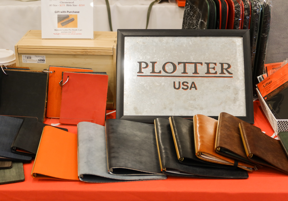 PLOTTER display with many Leather Binder samples on the table.