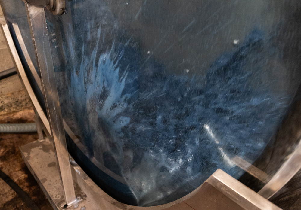 Indigo leather in a spinning dyeing drum with a tanning solution filled with wax and warm water. 