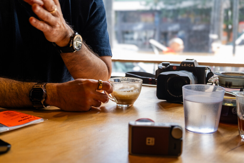 Man holding a coffee cup on wooden table.