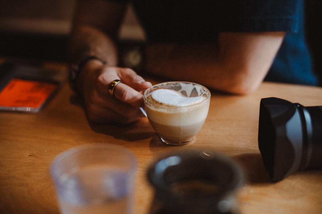 Man holding a coffee cup on wooden table.