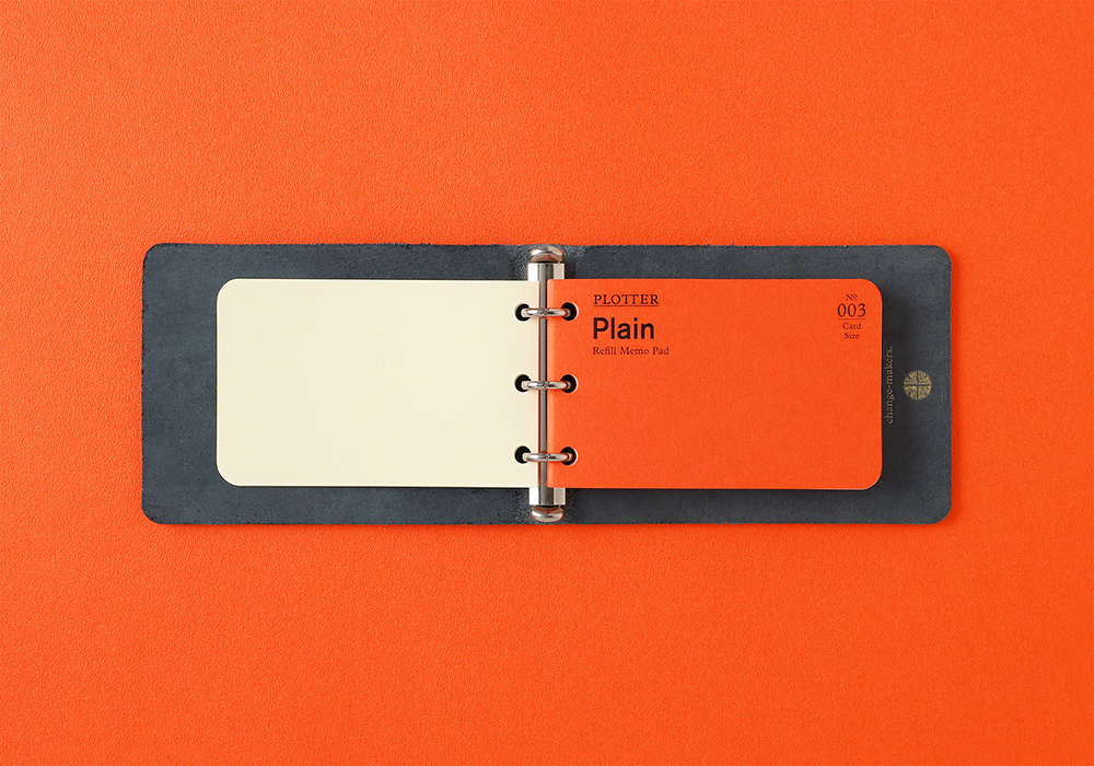 An opened 3-Ring leather binder with a Plain refill against an orange background.