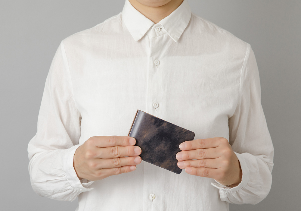 A person holding a 3-Ring Leather Binder in Unevenly Dyed Cordovan.