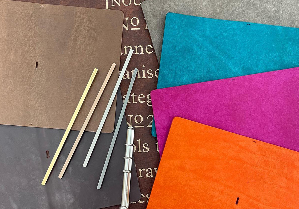 An array of special leather options in gray, blue, magenta, orange, brown, and dark brown on a table.