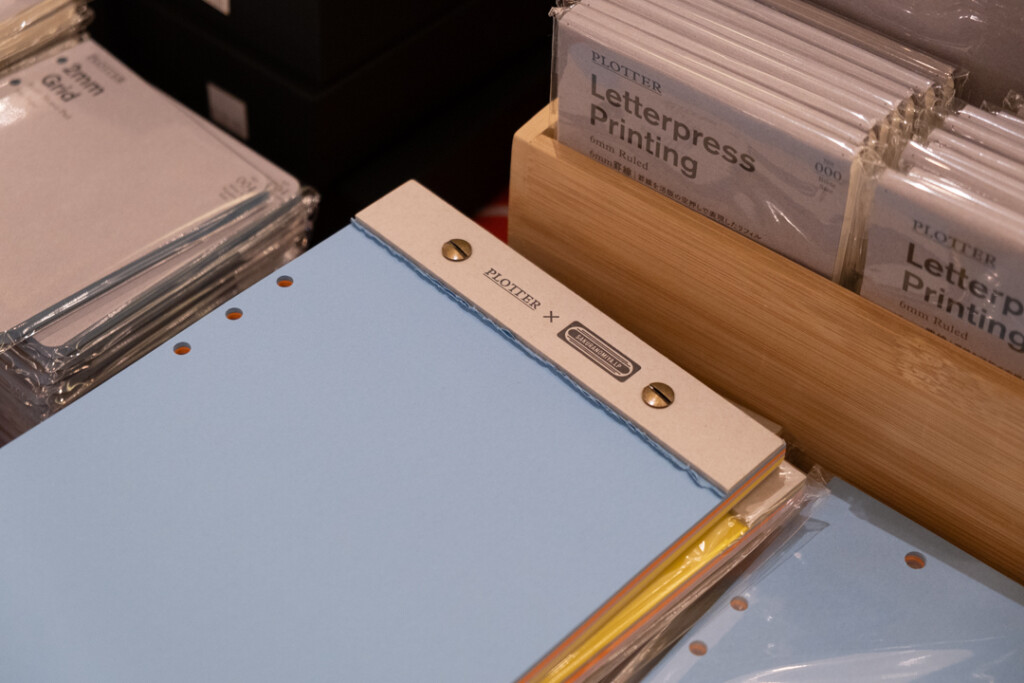 Desktop memo pad with various colors of paper on the PLOTTER USA table.