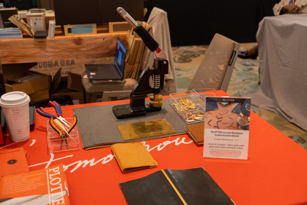 PLOTTER USA corner hardware machine beside other tools and PLOTTER Leather Binders on a table.