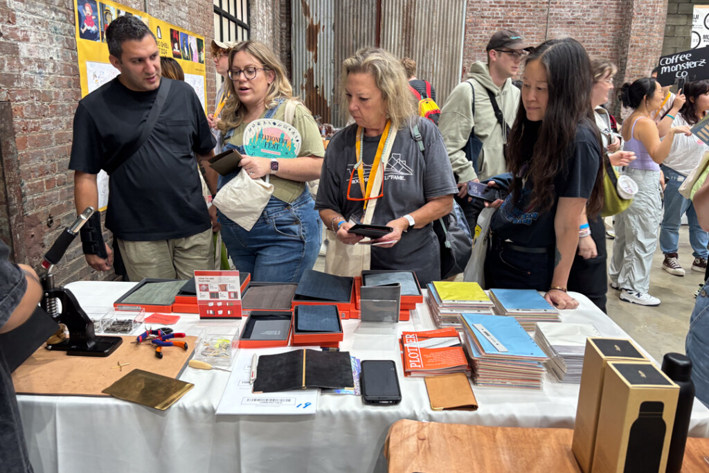 Customers shopping at the PLOTTER USA booth filled with Leather Binders at Stationery Fest.