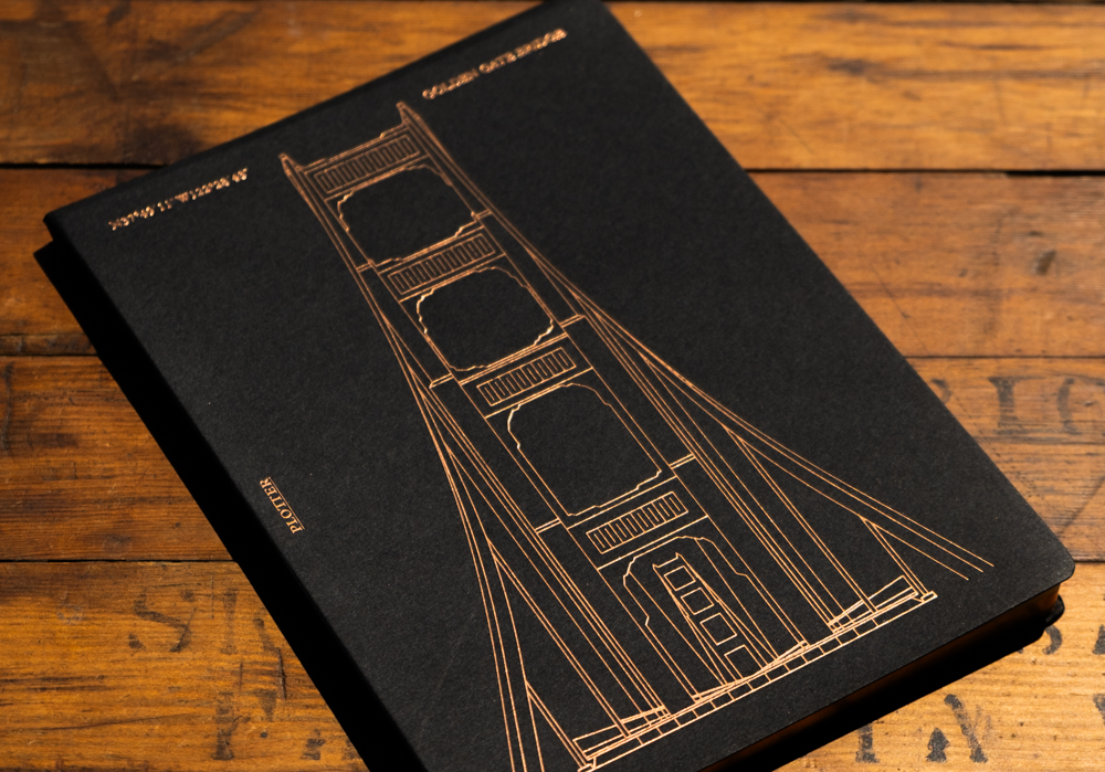 A close up look at the Limited Foil Stamping Golden Gate Bridge Notepad with copper foil stamping.