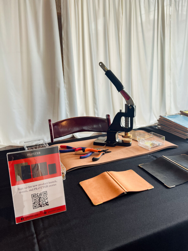 PLOTTER USA corner hardware machine beside other tools and PLOTTER Leather Binders on a table.