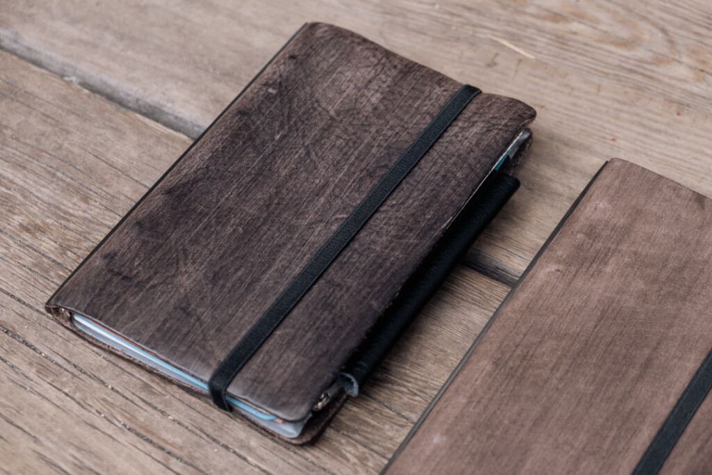 Close-up of two Gray PLOTTER Leather Binders in Horse Hair II Leather in Bible Size, highlighting the patina of the leather.