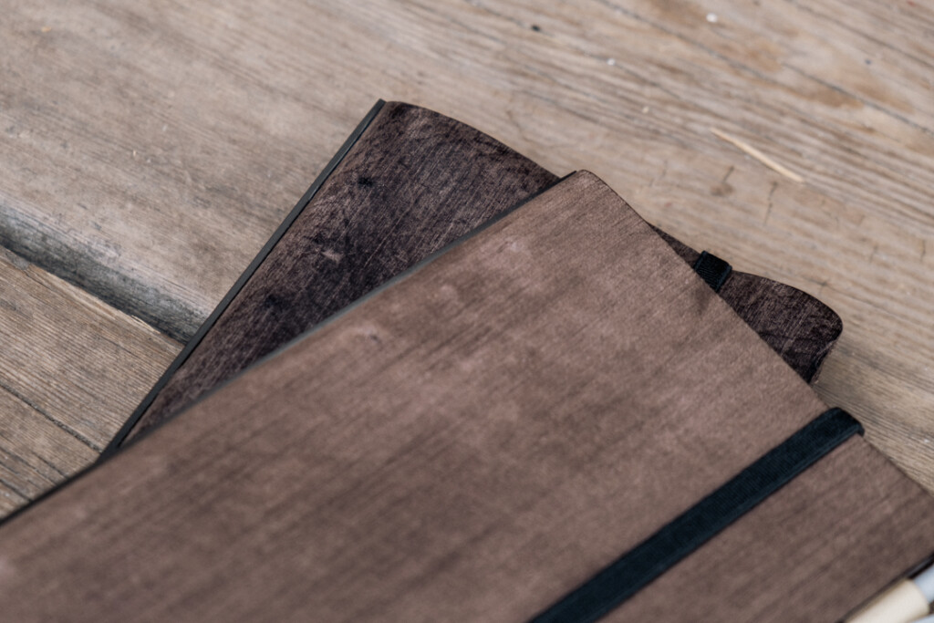 Close-up of two Gray PLOTTER Leather Binders in Horse Hair II Leather in Bible Size, highlighting the patina of the leather.