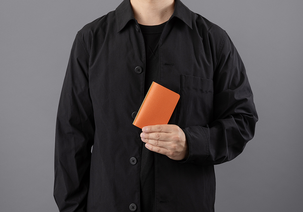 Man holding a PLOTTER Mini 5 Size in Shrink Orange.