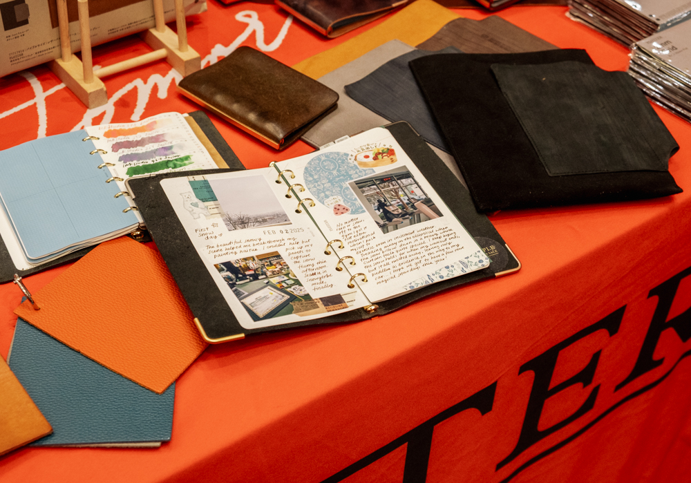 Samples of colorful ink swatches, and journaling in PLOTTER Leather Binders on the PLOTTER USA table at the California Pen Show.