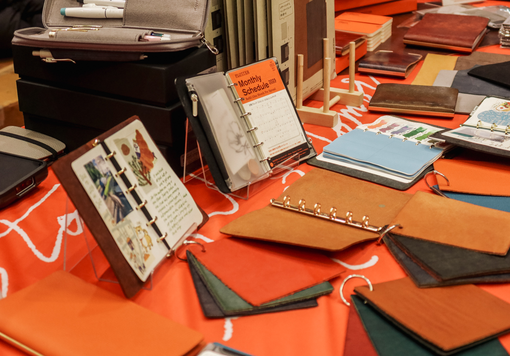 The PLOTTER USA table at the California Pen Show filled with leather samples and example PLOTTER Leather Binders.