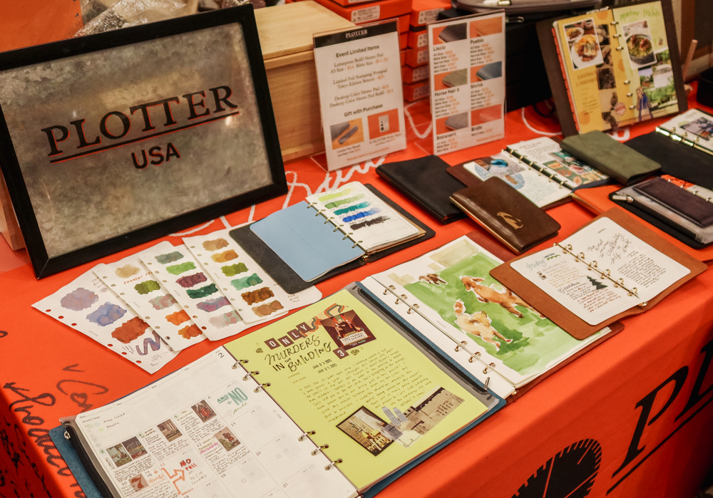 Samples of colorful ink swatches, paintings, and journaling in PLOTTER Leather Binders on the PLOTTER USA table at the California Pen Show.