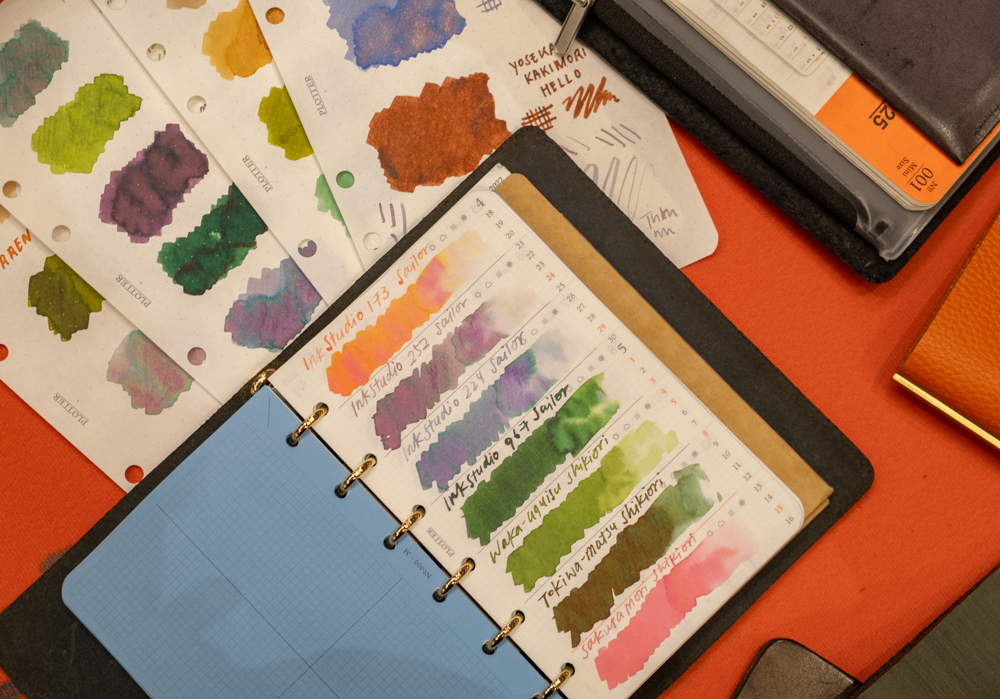 Samples of colorful ink swatches, paintings, and journaling in PLOTTER Leather Binders on the PLOTTER USA table at the California Pen Show.