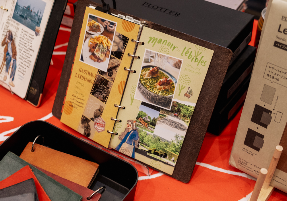 A Bible Size PLOTTER Leather Binder with colorful journaling on the PLOTTER USA table at the California Pen Show.