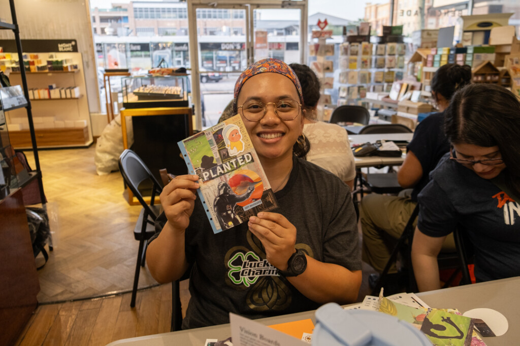 A student who attended the PLOTTER workshop holding their completed vision board.