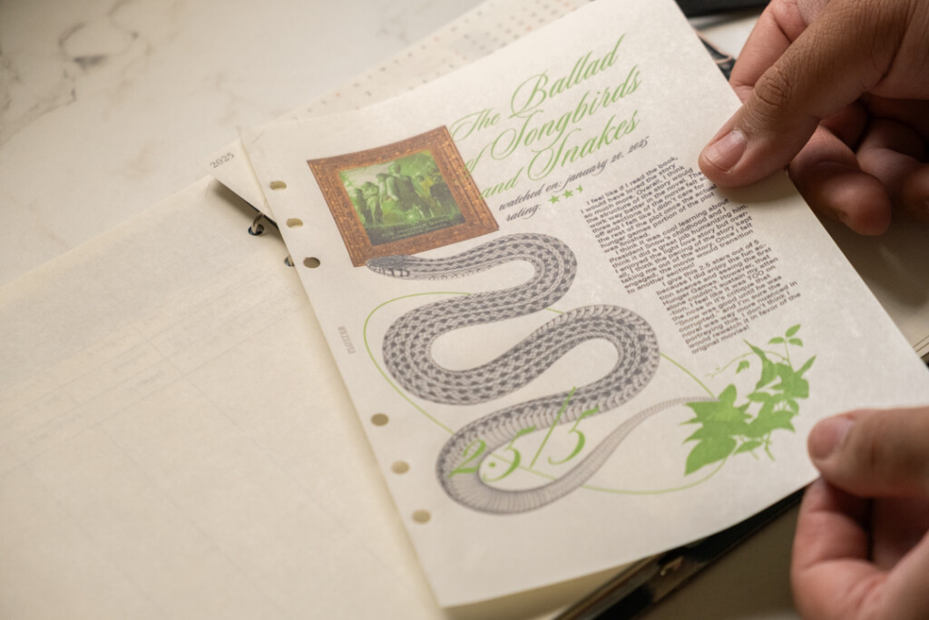 A person putting a printed sheet of A5 PLOTTER Paper into a PLOTTER Leather Binder.