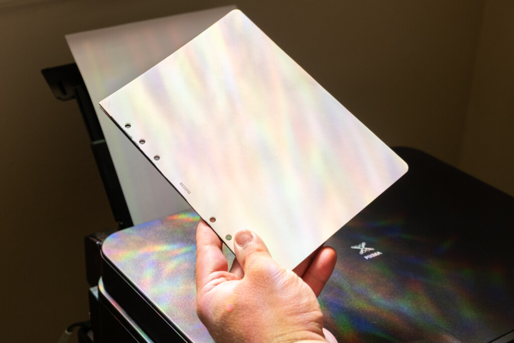 A person holding an A5 Refill Memo Pad in front of a printer.